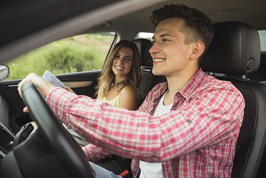 Jeune couple au volant d'une voiture